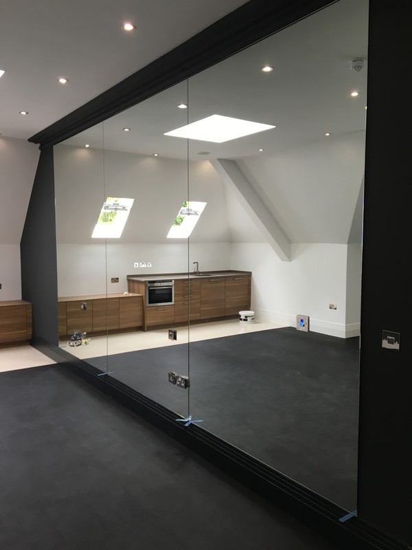 Frameless glass partition in loft conversion by Croydon glaziers